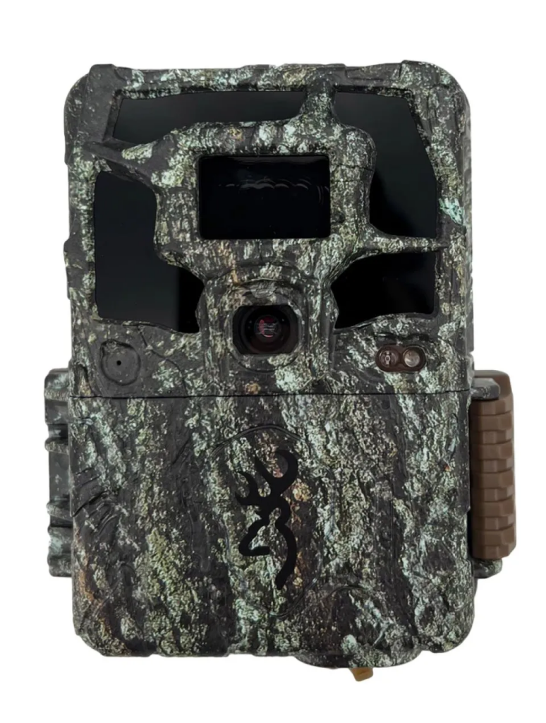 Trail camera facing towards the camera with camouflage coating with a white background.