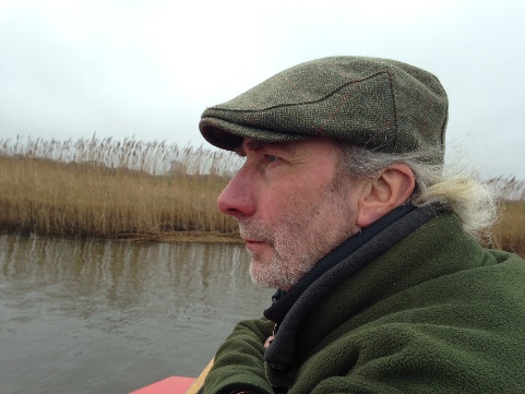 Author Simon Barnes gazing out over a river.