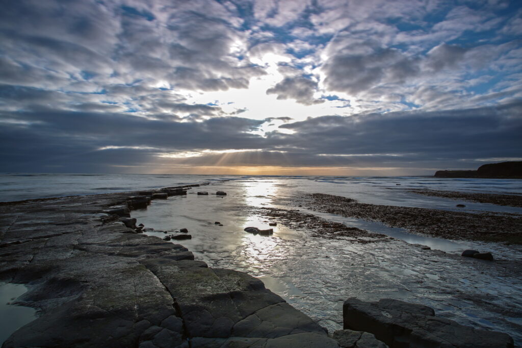Coastline in Dorset showing a rocky water edge and sunset