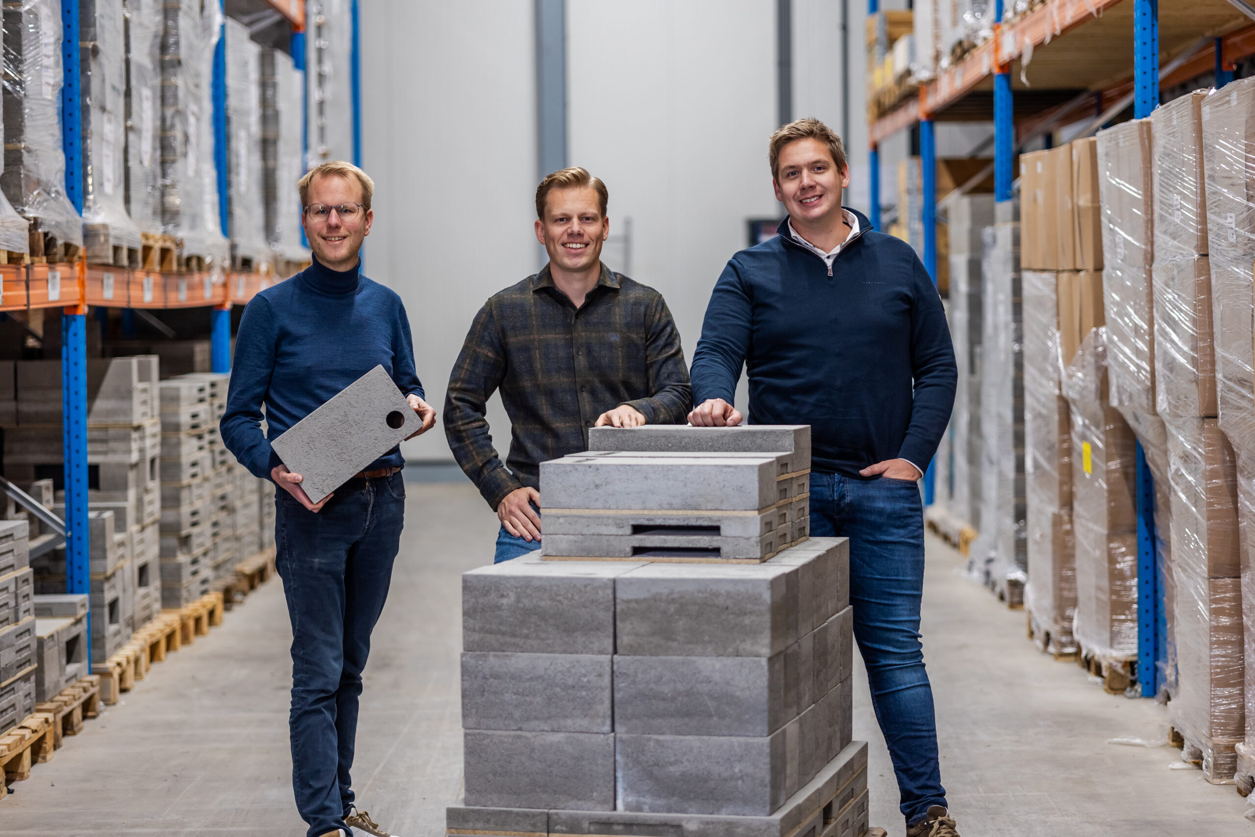 Photo of the three Unitura founders stood in their warehouse by a bat box.