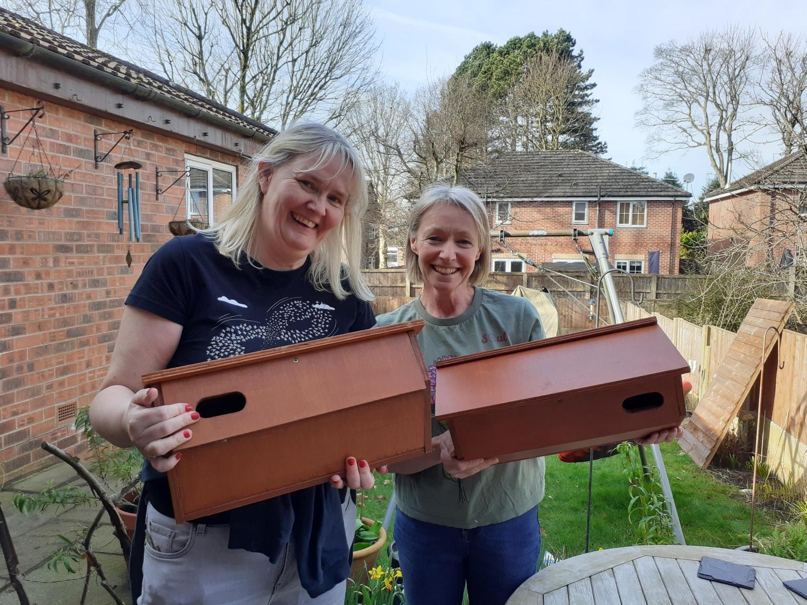 Residents Suzanne Pendleton and Kathleen Sides holding up the Swift boxes made by The Skills Company, Trafford.